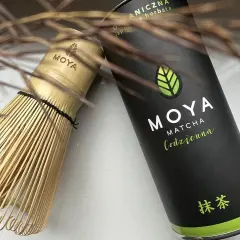 Tradycyjny bambusowy chasen obok puszki MOYA Matcha. Idealny zestaw, by dowiedzieć się, matcha co to jest i jak ją przygotować.