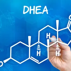 DHEA co to? Rysunek przedstawia wzór chemiczny DHEA, hormonu steroidowego, z ręką piszącą markerem.