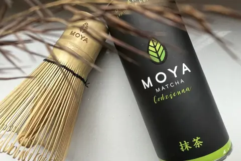 Tradycyjny bambusowy chasen obok puszki MOYA Matcha. Idealny zestaw, by dowiedzieć się, matcha co to jest i jak ją przygotować.