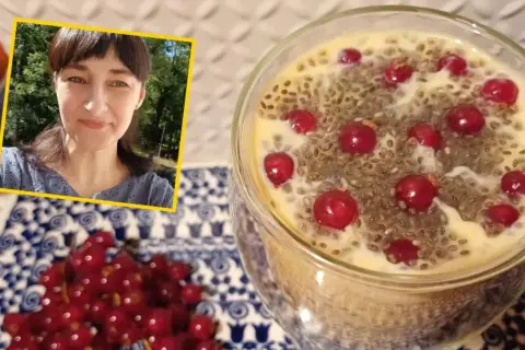 Uśmiechnięta kobieta obok deseru z nasionami chia i porzeczkami. Czy nasiona chia są zdrowe? Tak, to świetny dodatek do diety!